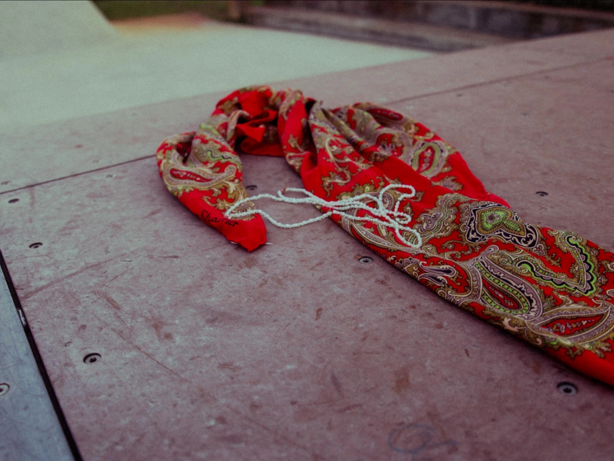 pearl necklaces and and a scarf lying on a halfpipe in a skate park