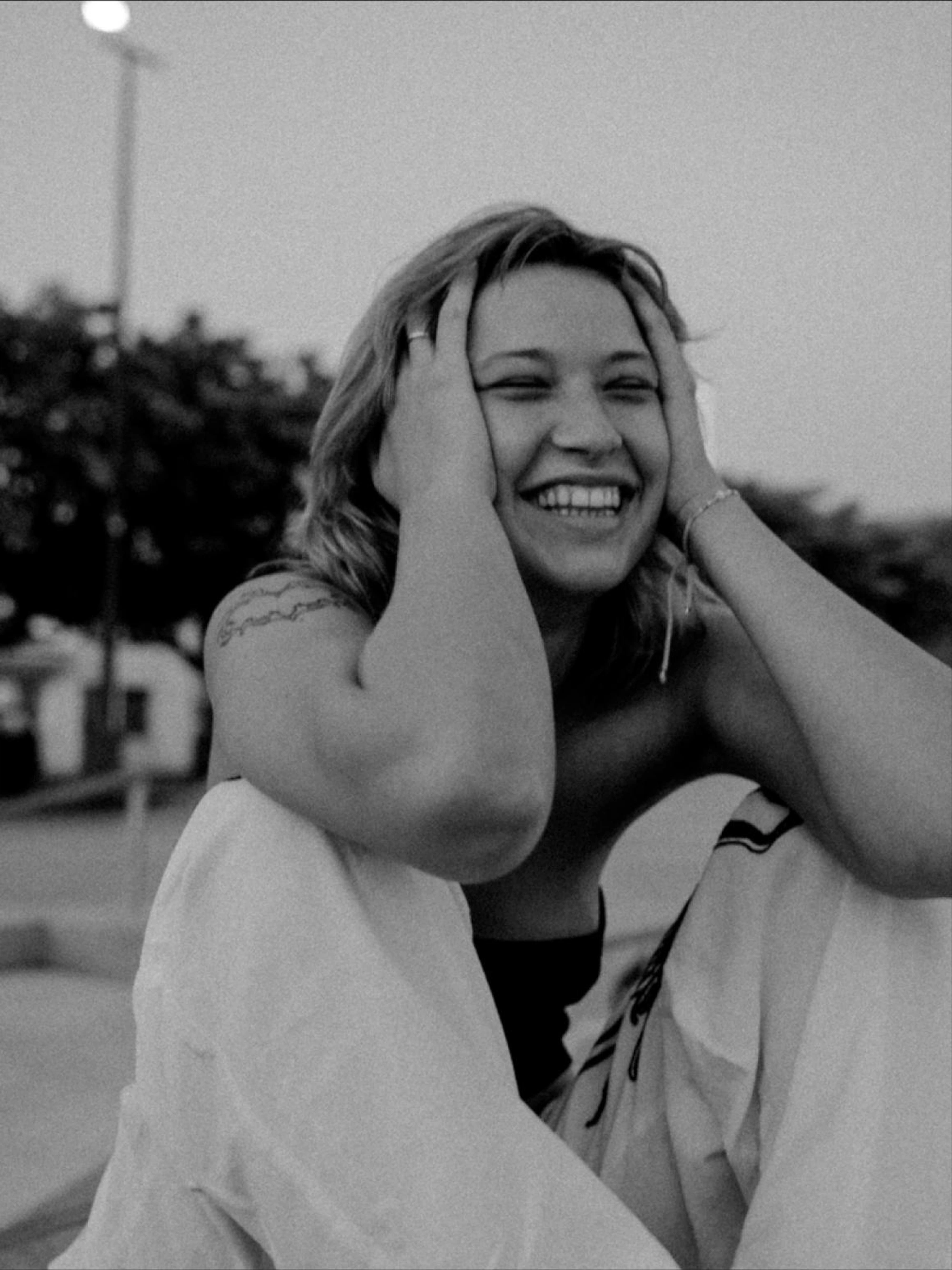 black and white portrait of a young woman sitting on a halfpipe in a skate park